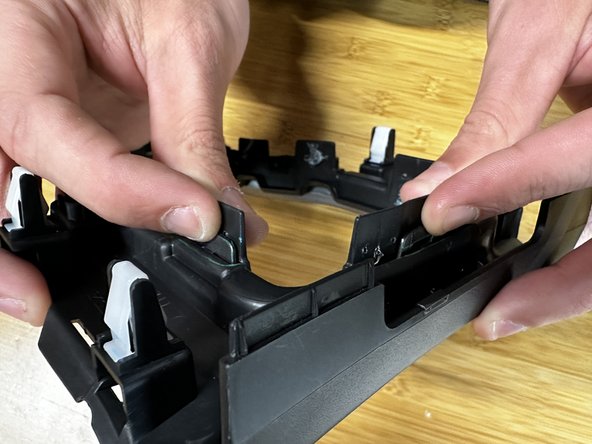 You can now remove the trim ring from the console cover. Depress the tabs and push the ring out.