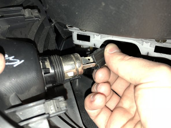 Depress the clip and unplug the accessory outlet and set the cover aside.