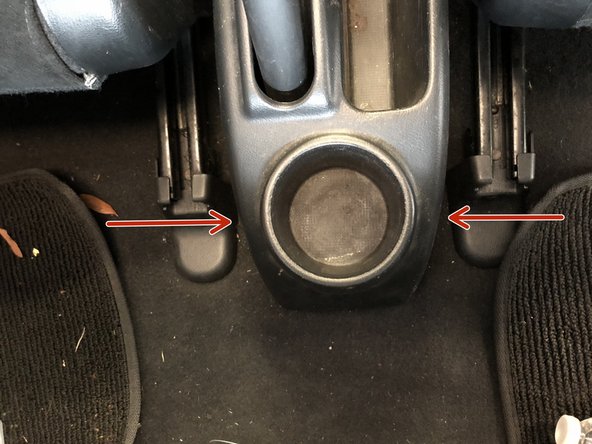 Locate the two screws holding the rear section of the center console in place.