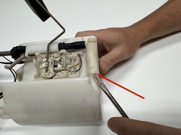 Unclip and disconnect the fuel pump hose. Remove it entirely so it does not interfere with the fuel level float.