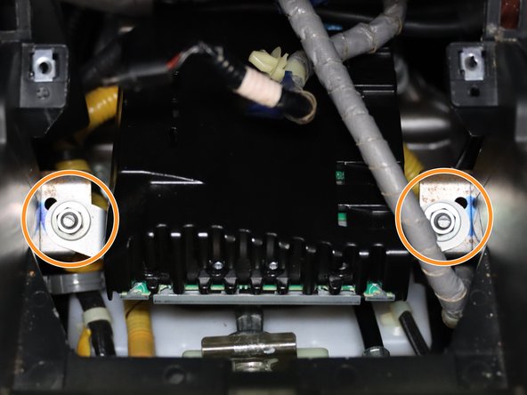 Mounted above the shifter is the stereo amp. There are (x2) 10mm nuts that hold it in place. Circled in orange, remove these two nuts and lift the amp out of the way.