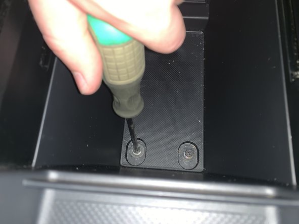Remove the two screws inside of the center console.