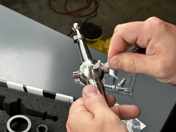 Apply one tube of grease around the outside of the center ball. Be sure to spread it evenly with your finger.