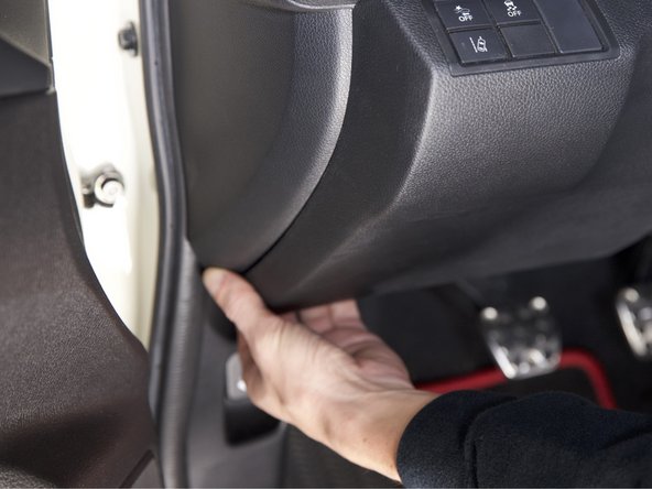 Pull outward on the bottom section of the lower dash panel. It should pop outward allowing you clear access to the fuse box and grounding location.