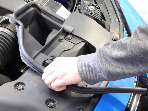 Begin in the engine bay by removing the air intake seal. You will need to remove the airbox lid so remove this section to make gaining access to the tray easier.