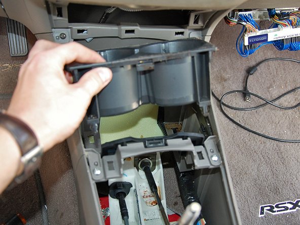 Slide the center console slider forward and remove the cup holder.