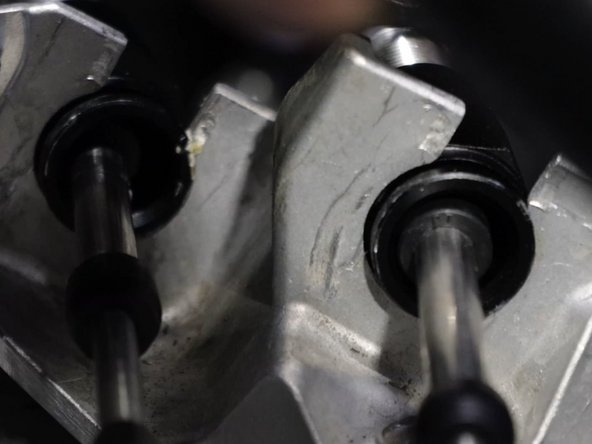 On the transmission, insert the shifter cables through the shifter cable bracket. Use the OEM retailing C clips and lock them into place.