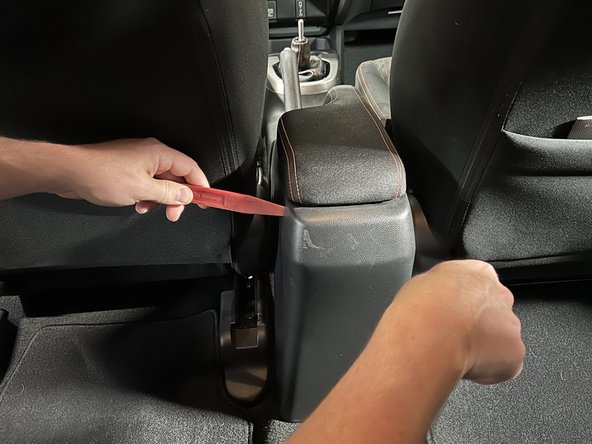 Using trim tools, pry the back section of the console off.
