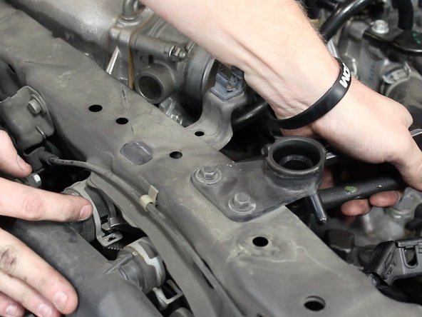 Using a pair of pliers, slide the hose clamps back. Remove the upper radiator hose.