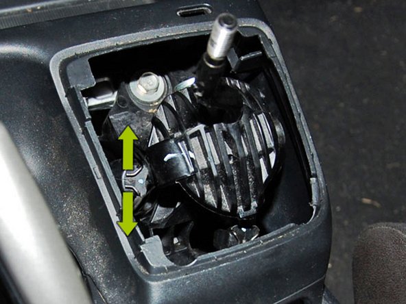 Now that the center console is not attached, slide it into the back seat to give yourself room to remove the cables from the shifter.