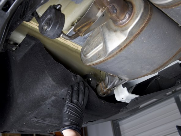 At the rear of the car, push the felt rear liners inward to expose the rear exhaust hangers.