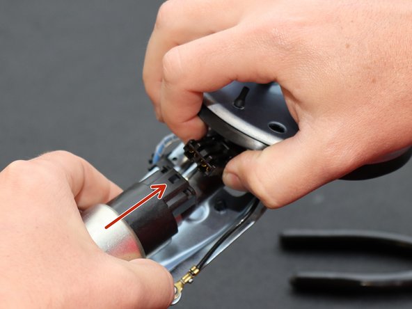 Disconnect the fuel pump by depressing the wire harness connector and pulling it outward.