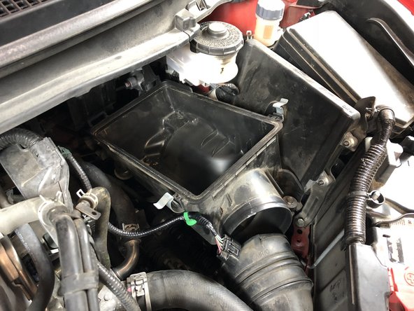 Using both hands, pull up on the airbox to remove it from the rubber mounts. This will expose the shifter cables.