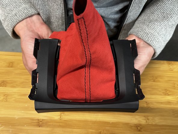 Use a trim tool, pick or flat screw driver and push the fabric through the trim. Make sure the boot is spaced evenly.