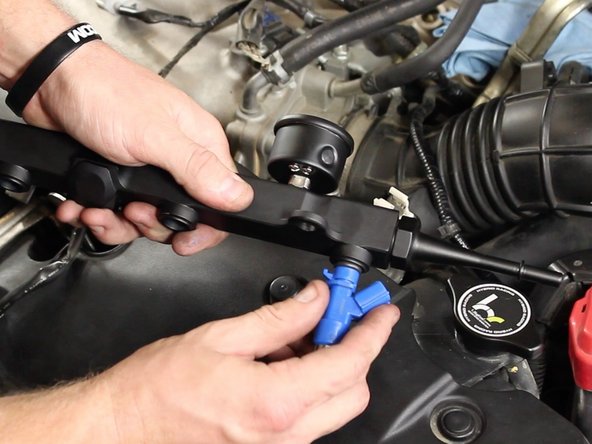 Insert injectors into the ports of the fuel rail. Make sure the wire harness connection clips are on the opposite side of the fuel rail mounting points.
