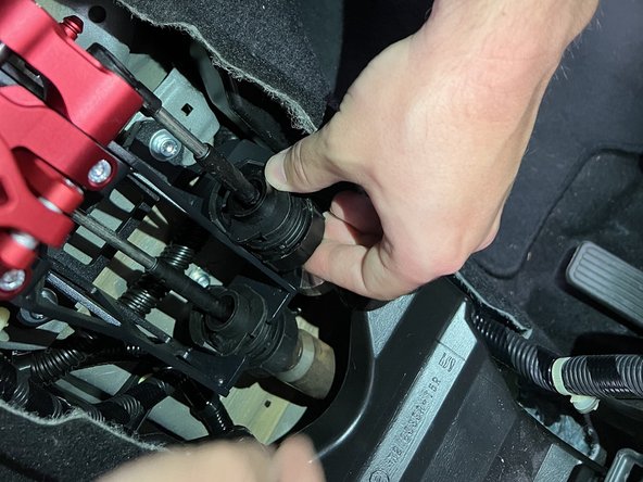 Rotate and slide the shifter cables back into their respective locations.