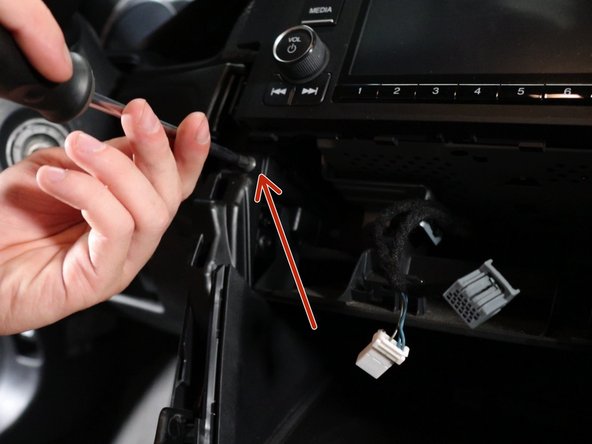 Remove the two phillips screws holding the side console trim sections in place.