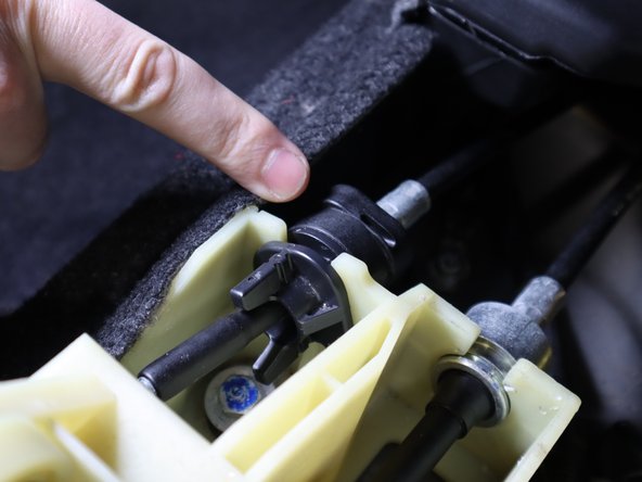 Remove the shifter cable by rotating the tab counter clockwise and sliding it out. The cable should be free.