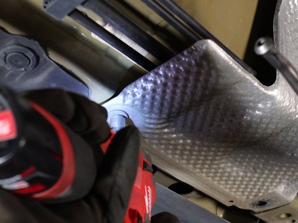 Unbolt and remove the lower heat shield. This will expose the shifter cables.