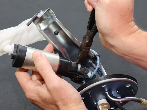 Use a pair of pliers and loosen the hose clamps that hold the rubber hose to the cage assembly.