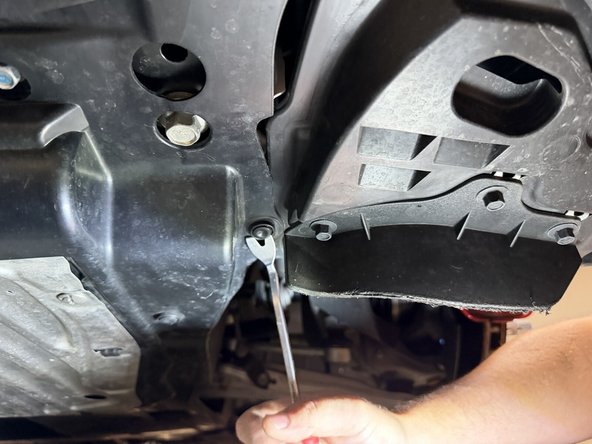 Remove the splash shield fasteners under the front of the car and drop the cover.