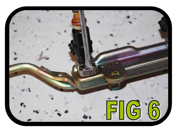 Using a flat-head screwdriver, pull the clips off holding all four (4) injectors in the stock fuel rail as shown in FIG 6. Note: Once you pull one injector out, fuel is going to flow out of the fuel rail. Make sure you have something ready to catch it.