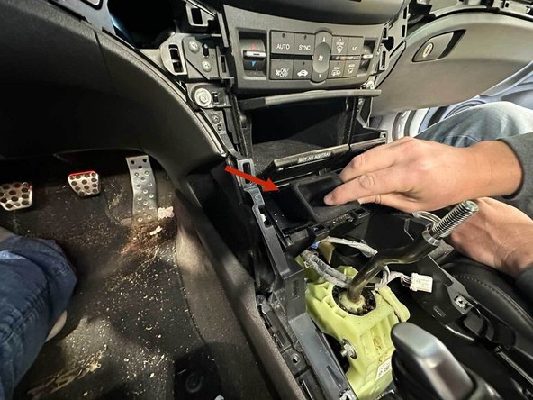 Flip the lid up and locate the coin pocket. Pull straight out while squeezing the hinge tabs.