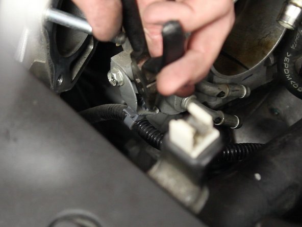 Un-clip the harness from the lower bracket on the throttle body.