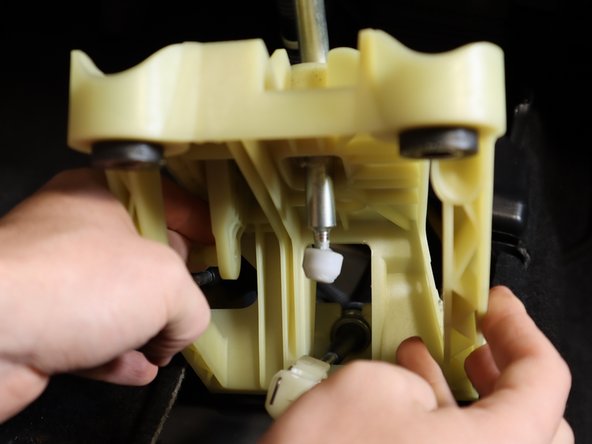 To remove the cable, spread the metal clips apart and the end link will slide off the shifter cup.