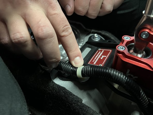 Reinstall the factory wiring harness so it clips into the shifter base.