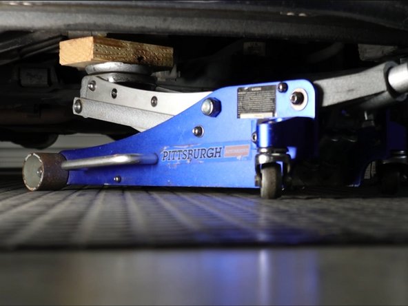 Locate a safe point under the transmission and use a floor jack to support the transmission while you remove the trans mount.