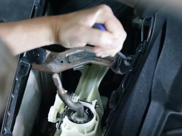 Use a Phillips screwdriver and remove the two screws that hold the console bracket in place.