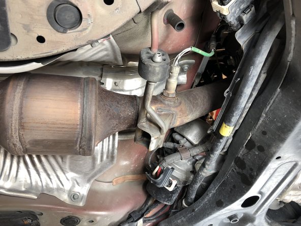 Locate the exhaust heat shield and remove the 10mm bolts holding it in place.