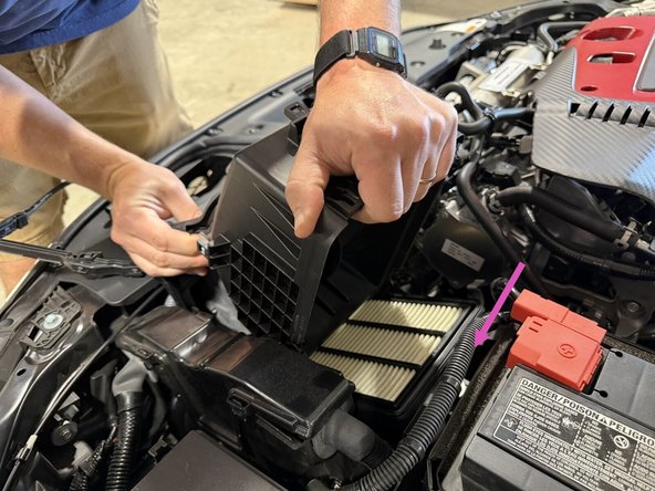 Release the clips and lift the air cleaner cover.