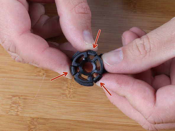 The tabs of the Delrin bushing must be compressed so it can clip into the cable end.