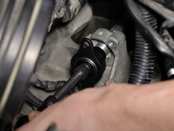 Insert the shifter cables through the transmission bracket. Don't bolt them down just yet since you might need to slide them.