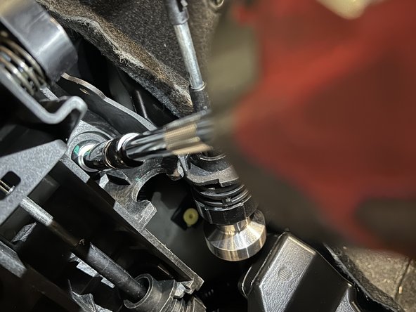 Remove the four shifter base mounting bolts.