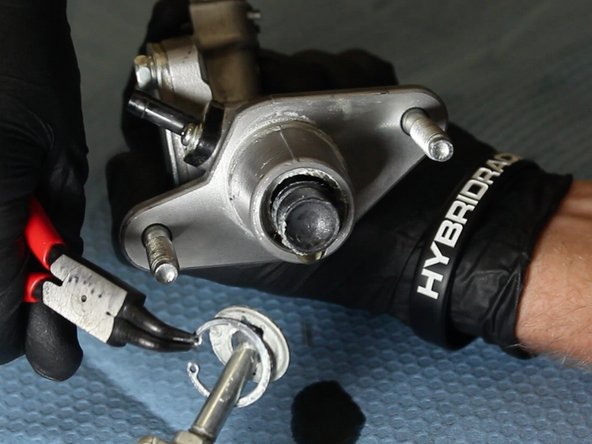 Using a pair of C-Clip pliers, squeeze the C-clip and remove the OEM CMC rod &amp; fork.