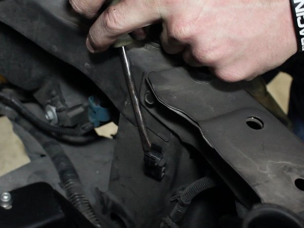 Remove the clip next to the radiator fill neck on the radiator support.