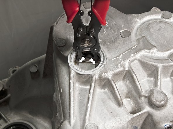 Scrape off any Honda Bond that is on the mating surfaces between the sealing cap and the transmission.