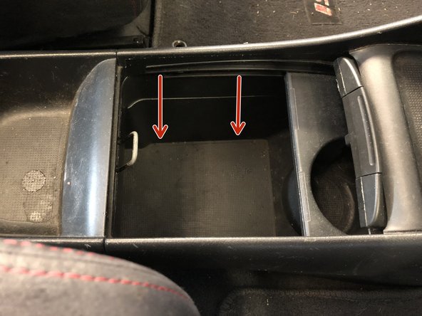 Unbolt the center console, by removing the lower cover. Underneath the mat there are 2 (10mm) bolts.