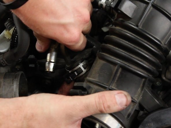 Unclamp and remove the valve cover vent tube from the intake tube.