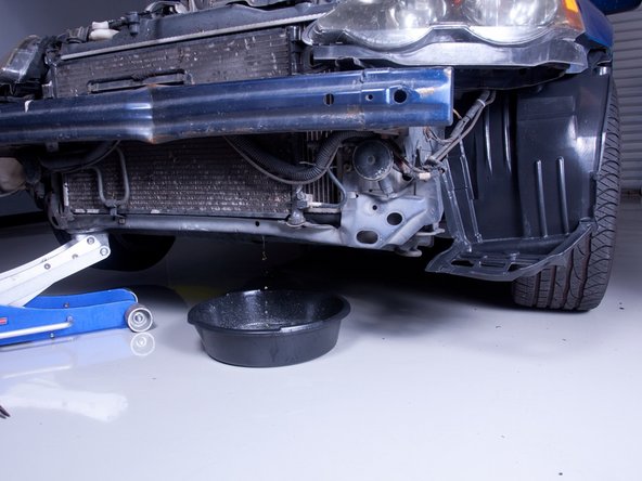Find a suitable jack point and raise the car enough to slide a drain pan under the radiator.