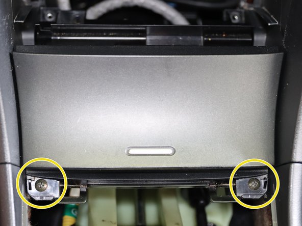 The lower coin pocked is held in with (x4) phillip screws. Two on top, two on the bottom. Remove all of them and the unplug the 12v socket on the back.