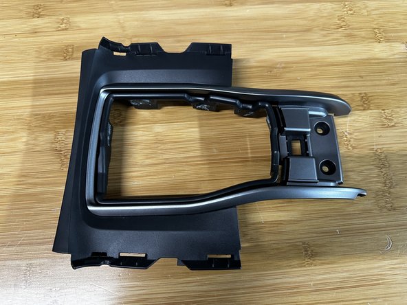 Flip the console cover over and pull the factory fabric out. It should slide out easily.