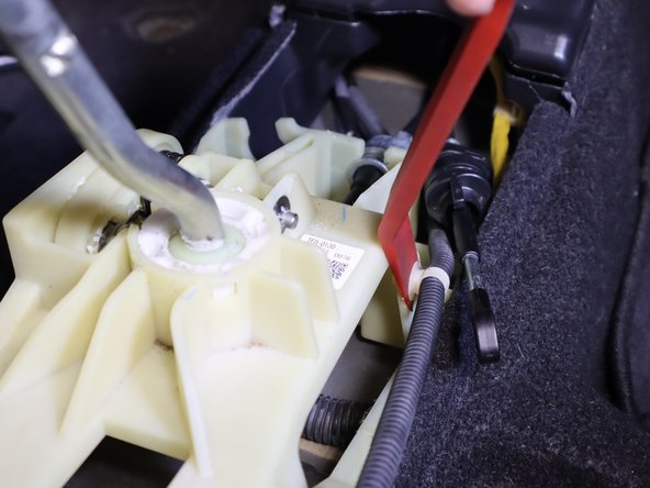 On the right side of the shifter, remove the wiring harness clip and move it out of the way.