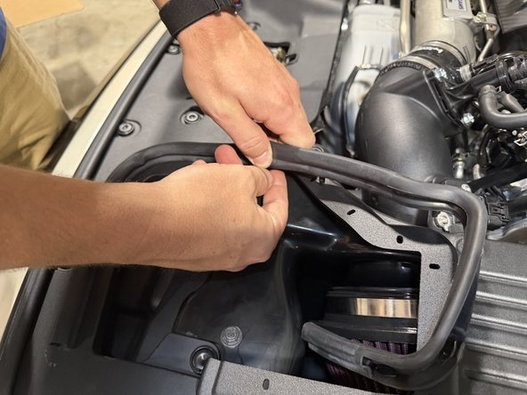 Press the rubber edge trim onto the top lip of the lid, working it around the full perimeter.