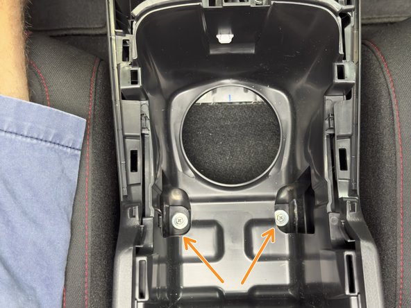 Remove the two 10mm mounting bolts under the cup holders.