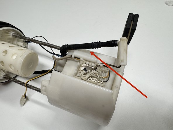 Unclip and disconnect the fuel pump hose. Remove it entirely so it does not interfere with the fuel level float.