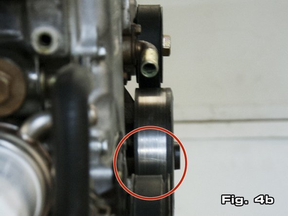 To install the belt onto the alternator, put a breaker bar with a 19mm (or 3/4”) socket on the bolt attaching the pulley to the autotensioner (see Figure 4a). In some cases, an open ended 19mm (or 3/4”) wrench may be preferred over a breaker bar. To rotate the pulley down, apply force to the breaker bar or wrench in a counter-clockwise direction.
